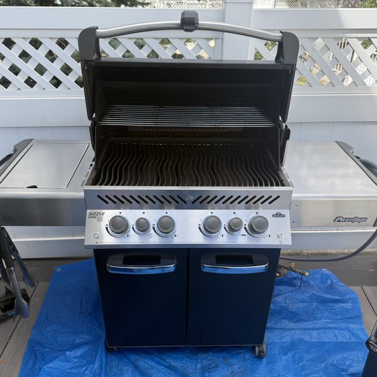 The same Napoleon Prestige barbecue after a full teardown clean, with clean grates, flavour bars and polished stainless