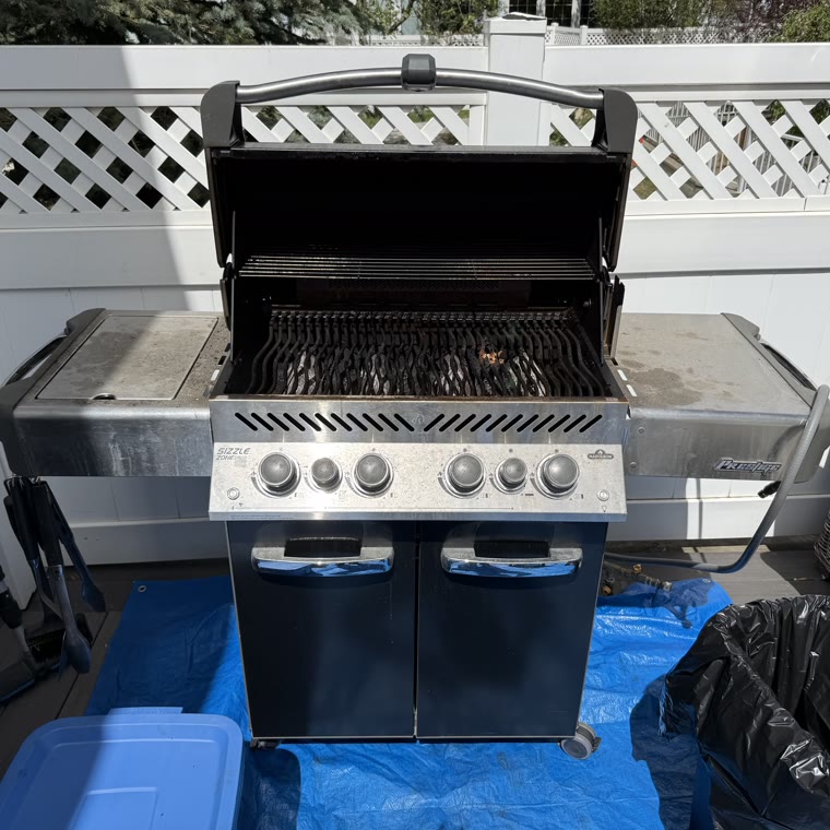 Napoleon Prestige gas barbecue on a Calgary deck before cleaning, with grates and flavour bars caked in burnt grease