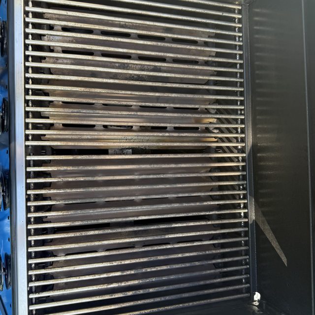 Barbecue grates and flavour bars removed and laid out during a Calgary BBQ cleaning