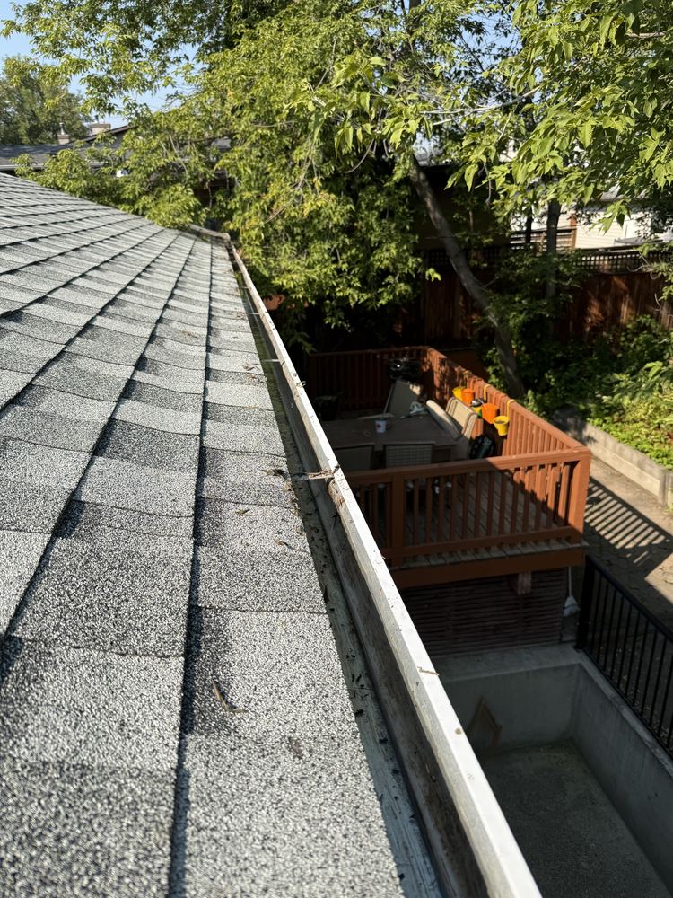 Clear, empty eavestrough running along the roof edge of a Calgary home after cleaning